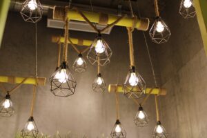 Modern hanging lights with geometric metal frames in an industrial-style interior.